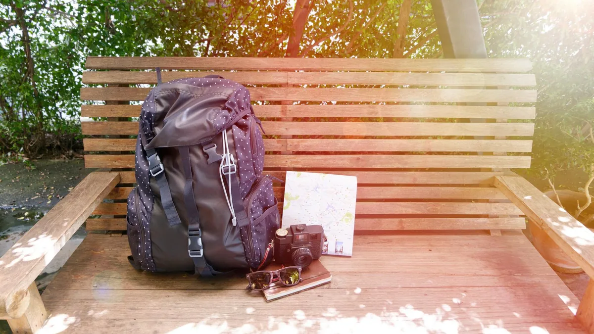 AD creative featuring a travel backpack, camera, and map