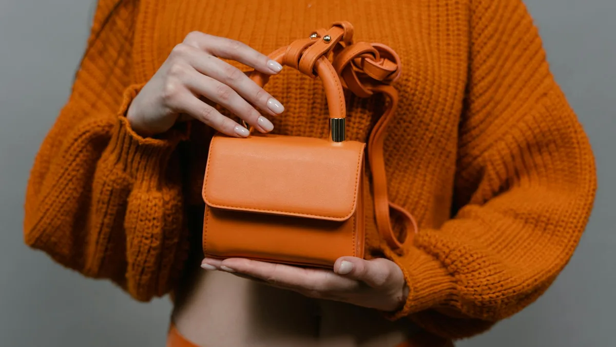 Woman carrying an orange leather handbag